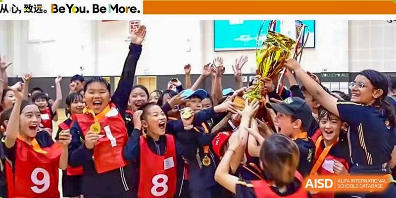 A group of excited students from Hiba Academy Nantong cheering and raising their hands in celebration after a sports competition or academic victory.