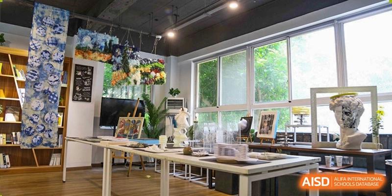 Bright, modern art studio or classroom with large windows, display tables, and plants at Milton International School Qingdao.