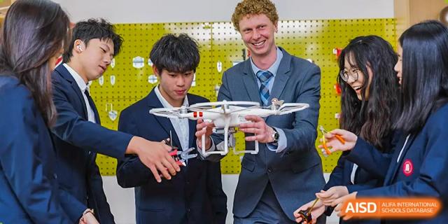Teacher and student holding a drone during a technology or robotics class at Milton International School Qingdao.
