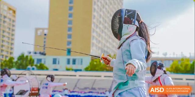 Student in protective gear practicing fencing outdoors at Milton International School Qingdao.