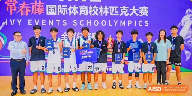 A group of male students from Milton International School Qingdao holding up a large trophy and individual awards after winning an inter-school sports competition.