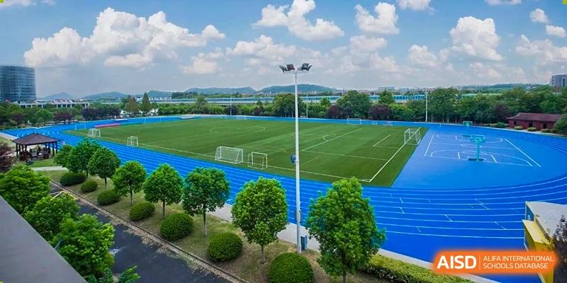 Nanjing International School aerial view of the outdoor sports facilities, including a soccer field and blue running track.