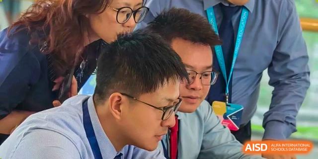 A close-up shot of Nord Anglia Chinese International School Shanghai faculty or parents collaborating and looking at a screen during a professional meeting or event.