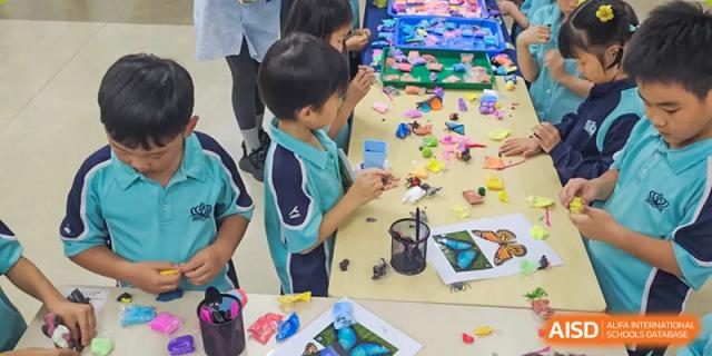 Young Nord Anglia Chinese International School Shanghai students engaging in a hands-on learning activity, building with colorful blocks and working with craft materials.