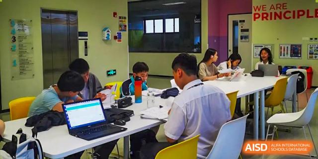 Nord Anglia Chinese International School Shanghai staff members attending a training session or meeting in a classroom with laptops.