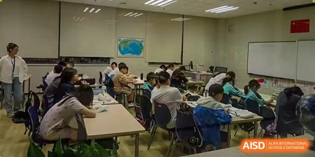 A meeting or professional development session taking place in a classroom at Nord Anglia Chinese International School Shanghai, with adults sitting at tables.