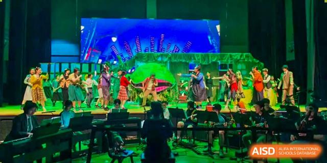 Nord Anglia Chinese International School Shanghai students performing on a brightly lit stage during a concert or musical event.
