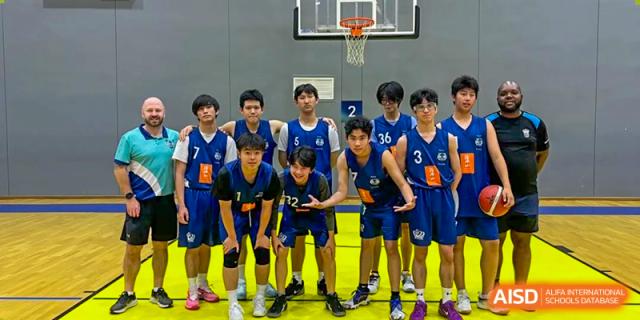 The school's basketball team posing together in their blue and white uniforms inside a gymnasium at Nord Anglia International School Shanghai, Pudong.