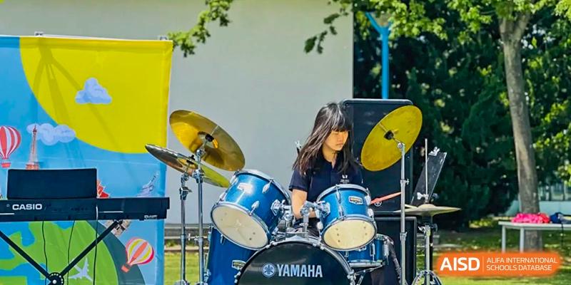 A student playing a Yamaha drum kit outdoors during a performance or practice session at Nord Anglia International School Shanghai, Pudong.