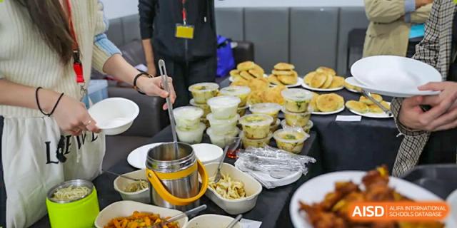 Individual servings of food and small bowls of snacks on a table at a food service station at Nord Anglia International School Shanghai, Pudong.