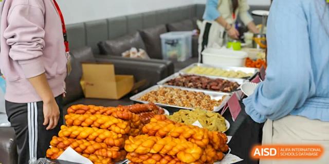 A buffet table featuring large trays of brightly colored and appealing cooked dishes and sides at Nord Anglia International School Shanghai, Pudong.