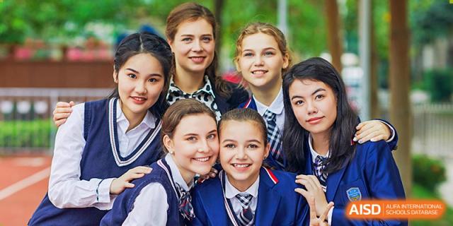 A close-up group photo of seven smiling female RDF International School students in uniform.