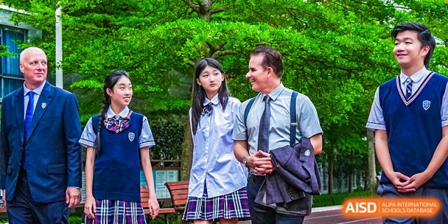 Two RDF International School students, a girl and a boy, in uniform walking together outdoors.