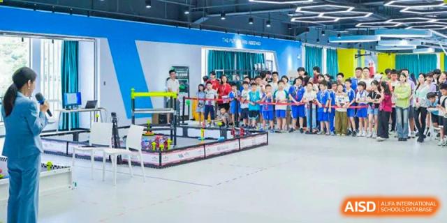 A group of RDF International School students and staff posing for a photo at a robotics competition or exhibit booth.