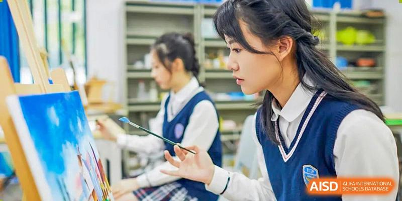 Two RDF International School students in uniform reviewing a document in the library or classroom.