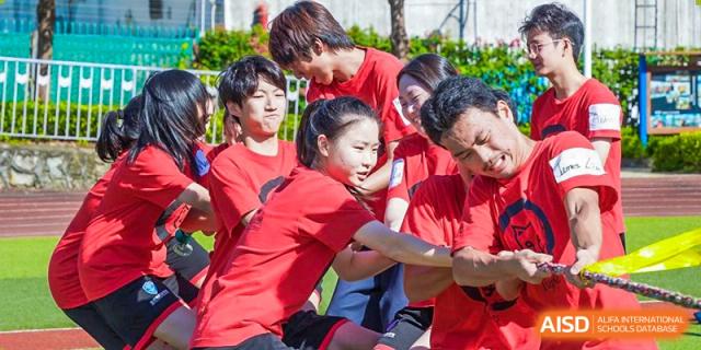 Students in red shirts participating in a tug-of-war competition during sports day at RDF International School.