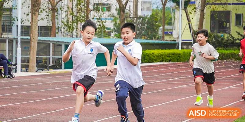 Young students running a sprint race on the track at RDF International School.