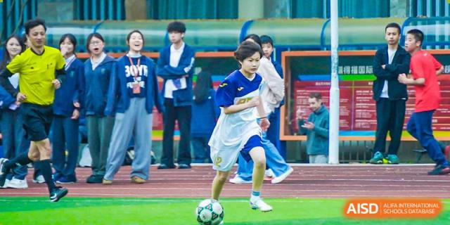 An RDF International School student playing soccer during a game on the field.