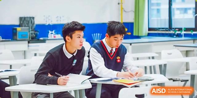 Two RGS Guildford Nanjing students in school uniform working together at a desk.
