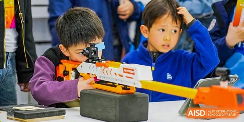 A close-up of a student looking through a scope on a toy gun during an activity at RGS Guildford Nanjing.