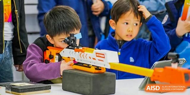 A close-up of a student looking through a scope on a toy gun during an activity at RGS Guildford Nanjing.