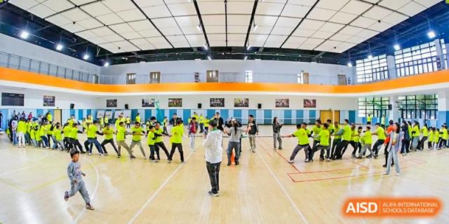 Students participating in a physical education or sports activity in the large indoor gymnasium at RGS Guildford Nanjing.