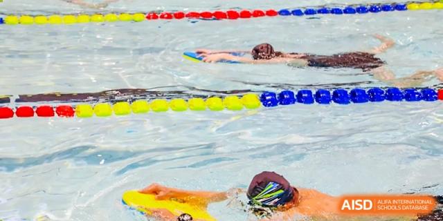 A close-up of a student swimming freestyle in the pool during a practice session at RGS Guildford Nanjing.