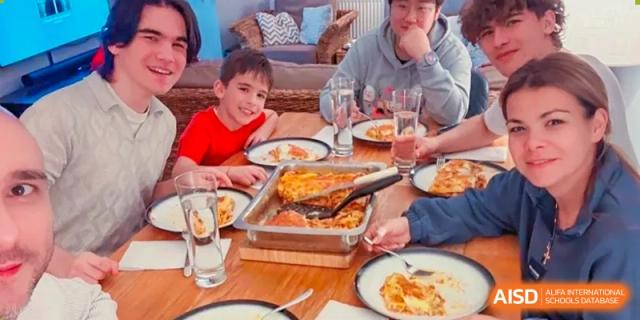 A group of people, including a young boy, enjoying a meal together at RGS Guildford Nanjing.