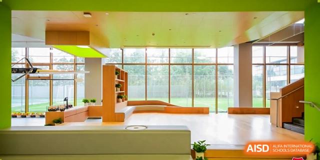 A wide interior view of a modern library or study lounge with floor-to-ceiling windows and clean, contemporary furniture at Shanghai DTD Academy.