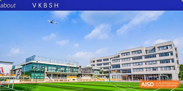 An exterior view of the modern campus of Shanghai DTD Academy, featuring a well-maintained green sports field and academic buildings under a clear blue sky.