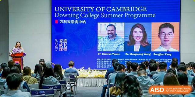 People sit in an audience watching a presentation on a screen advertising a University of Cambridge summer program, likely in collaboration with Shanghai DTD Academy.