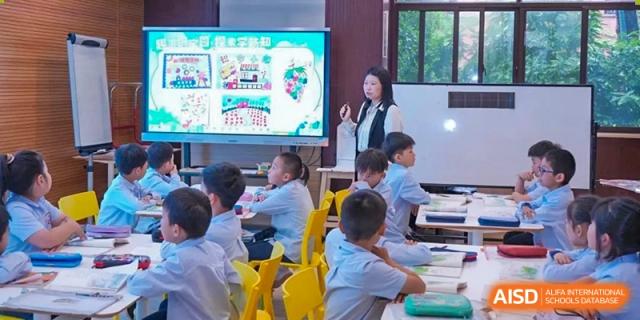 Students from Shanghai New Epoch Bilingual School seated at bright yellow desks in a classroom, engaged in a lesson.
