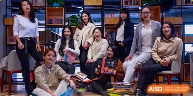 A small group of students and adults from Shanghai New Epoch Bilingual School gathered together for a discussion or meeting in a comfortable setting.