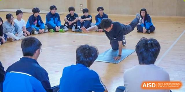 Students from Shanghai New Epoch Bilingual School participating in an exercise, yoga, or physical education class indoors.