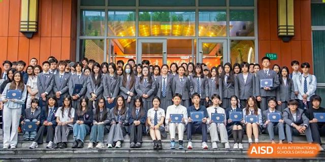 A large group of students from SHENGHUA ZIZHU ACADEMY posing for a formal group photograph on a set of steps.