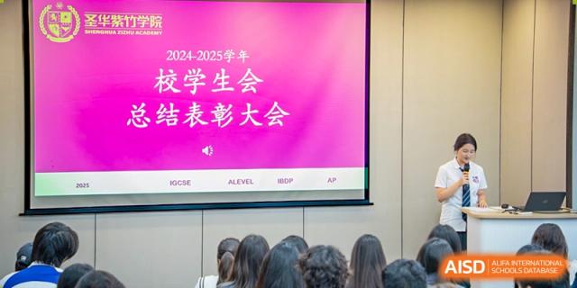 Students from SHENGHUA ZIZHU ACADEMY sitting in a lecture hall while a screen displays text that translates to "Student Union Commendation Conference."