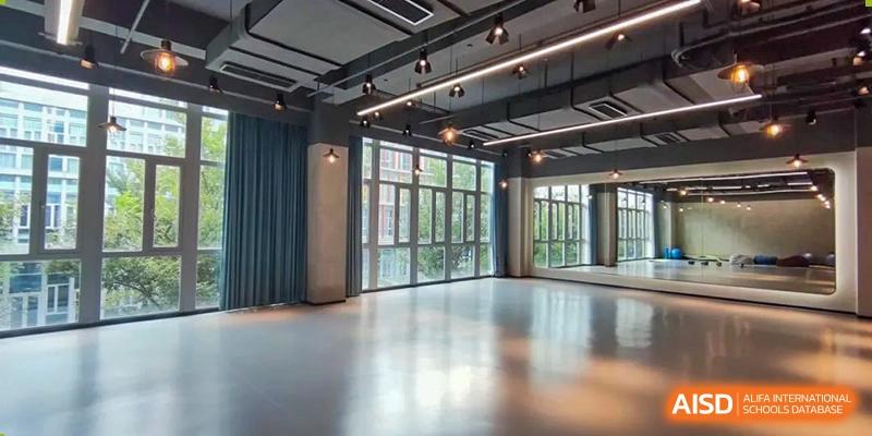 A bright, open, and empty studio or multi-purpose room with large windows at SHENGHUA ZIZHU ACADEMY.