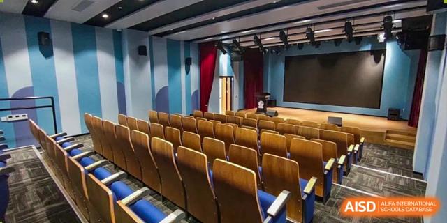 A bright, open student lounge or dining area at SHENGHUA ZIZHU ACADEMY with white round tables, modern chairs, and tall windows.