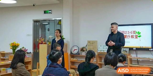 A teacher instructing or talking to a group of students in a focused learning environment at Shenzhen American International School.