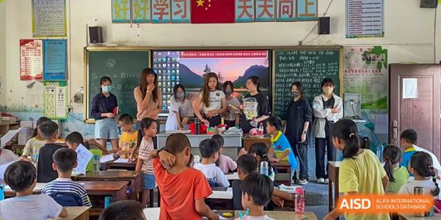 Students and teachers gathered around a desk for an interactive classroom activity or demonstration at Shenzhen American International School.