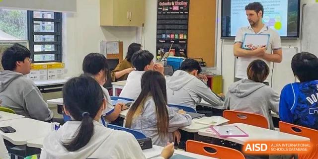 Older students working at desks in a classroom, focusing on their schoolwork at Shenzhen American International School.