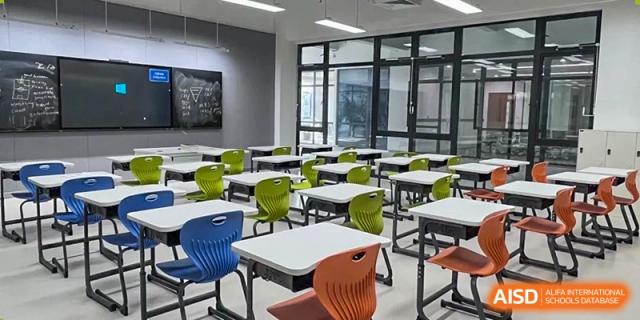 A modern, brightly lit classroom with empty desks and chairs at Shenzhen American International School.