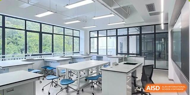 A bright, modern classroom or lab space with empty tables and chairs at Shenzhen American International School.
