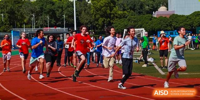 Students participating in a running race on an outdoor track during a sports event at Shenzhen American International School.