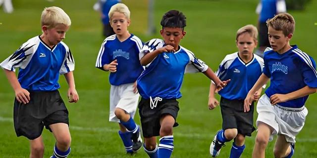 Two young boys running after a soccer ball during a game on a turf field at Shenzhen American International School.