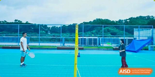 An outdoor sports court with a net pole, possibly for tennis or volleyball, at Shenzhen American International School.