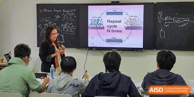 A student presenting or discussing a concept displayed on a large screen to classmates in a science or math class at Shenzhen College of International Education.
