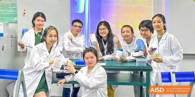 A teacher or mentor in a white coat helping students with a hands-on science or medical-related model at Shenzhen College of International Education.