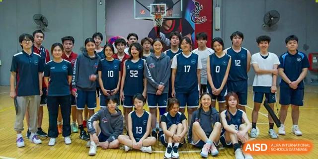 A group of male and female students in basketball jerseys posing for a team photo at Shenzhen College of International Education.