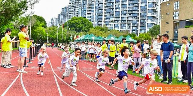 Young children running a race on an outdoor track during a school sports event at Shenzhen College of International Education.